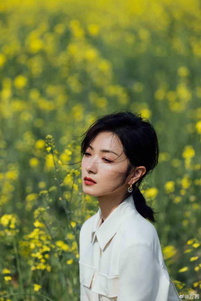万茜晒照承包油菜花田 穿白衣浅笑温柔迷人